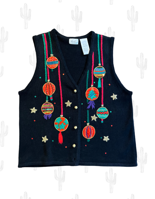 Front image of black knit holiday sweater featuring ornaments and sequins on white background.