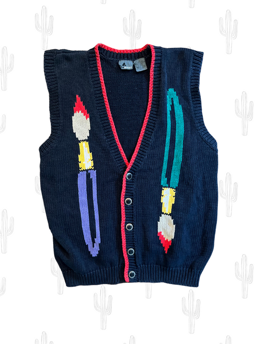 Front image of black knit sweater vest featuring paint brushes on white background.