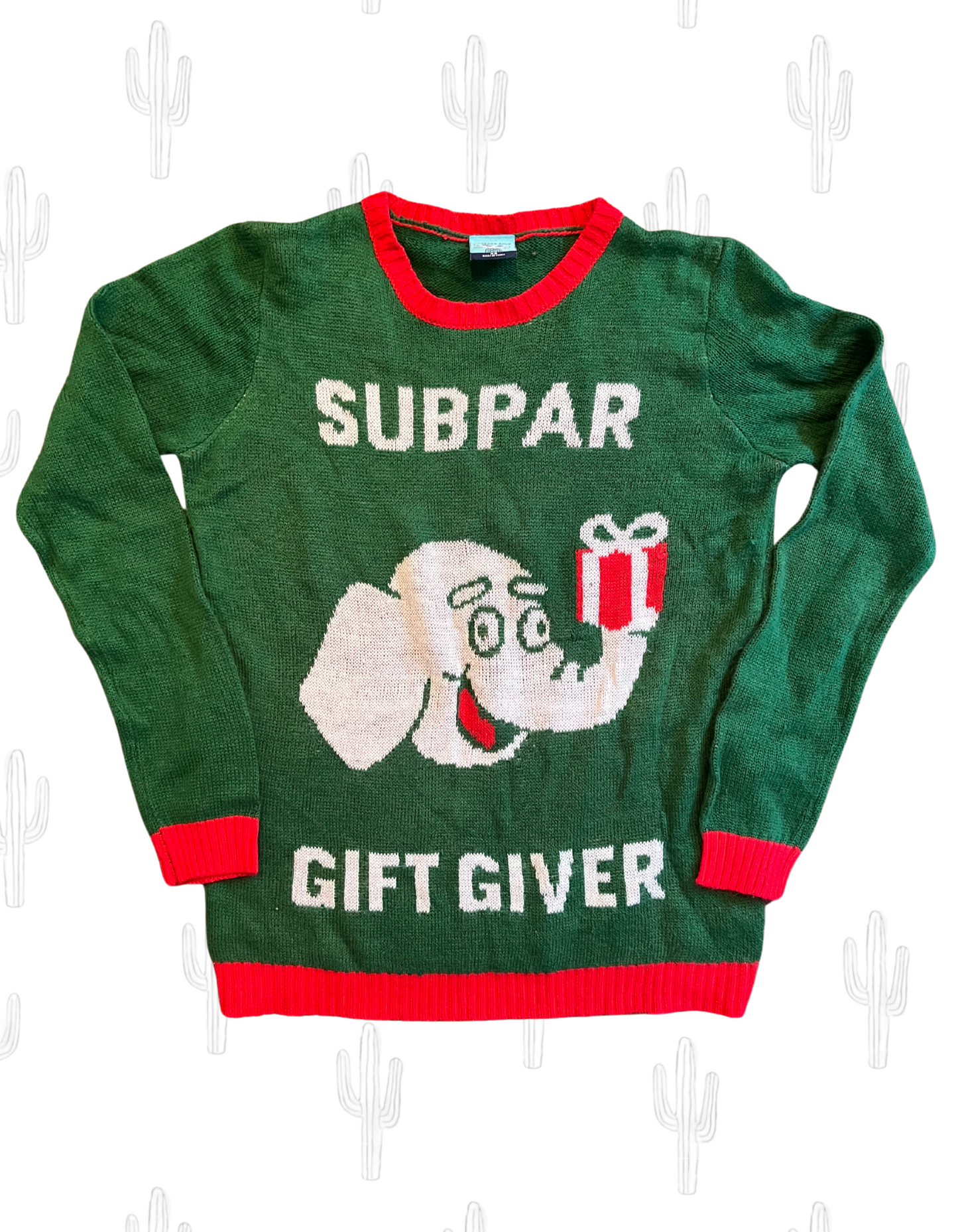 Front image of green and red sweater featuring elephant holding a gift with text reading subpar gift giver on white background.