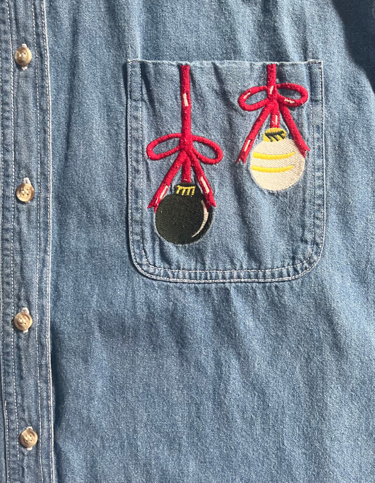 Front image of vintage denim jingle bells embroidered button up on light background.