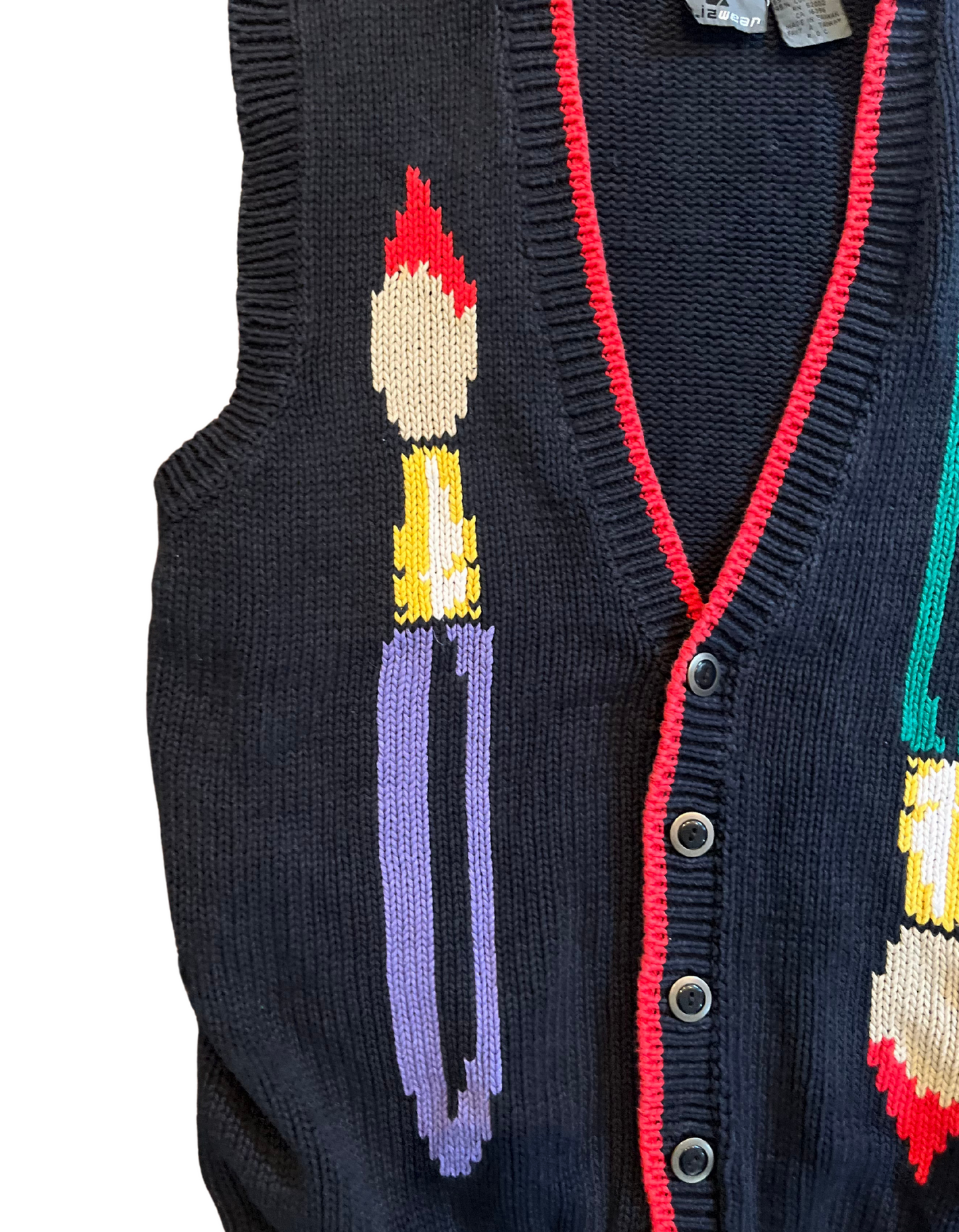 Close up image of black knit sweater vest featuring paint brushes on white background.