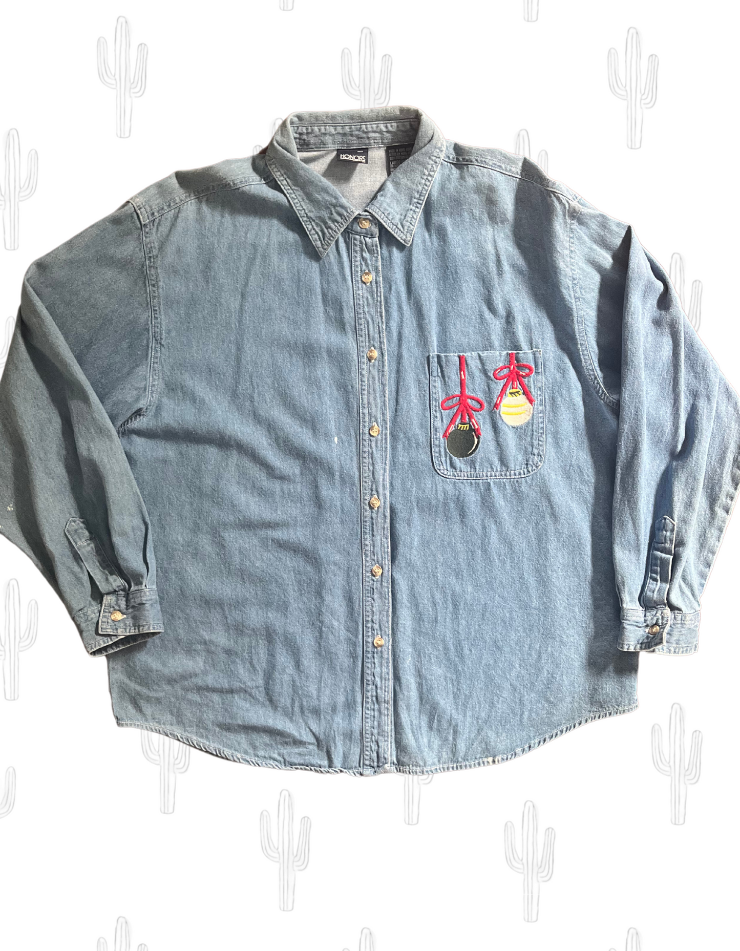 Front image of vintage denim jingle bells embroidered button up on light background.