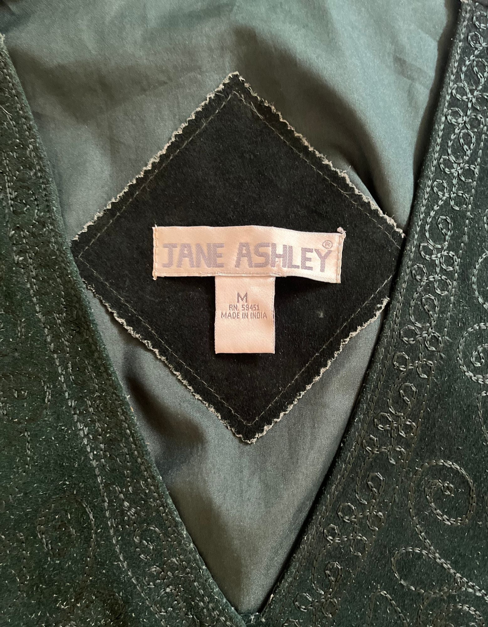 Close up image of tag on vintage emerald green Jane ashley vest.