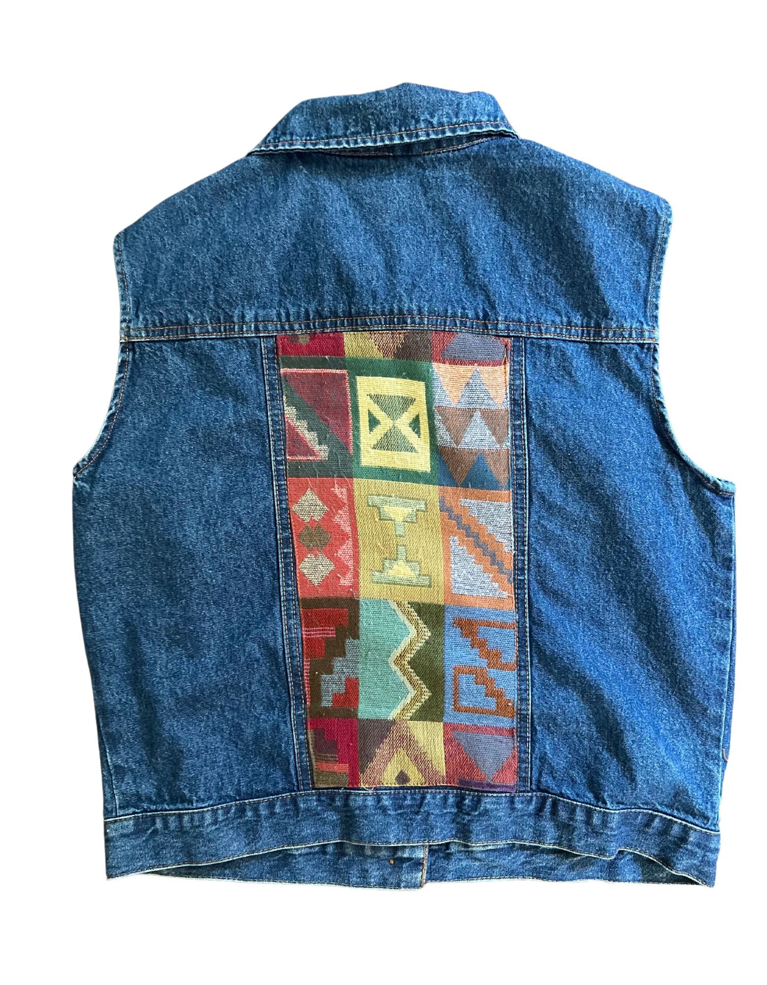 Back of vintage denim vest with printed fabric inserts.