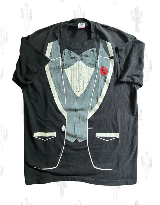 Front image of black tshirt with tuxedo graphic on light colored background.