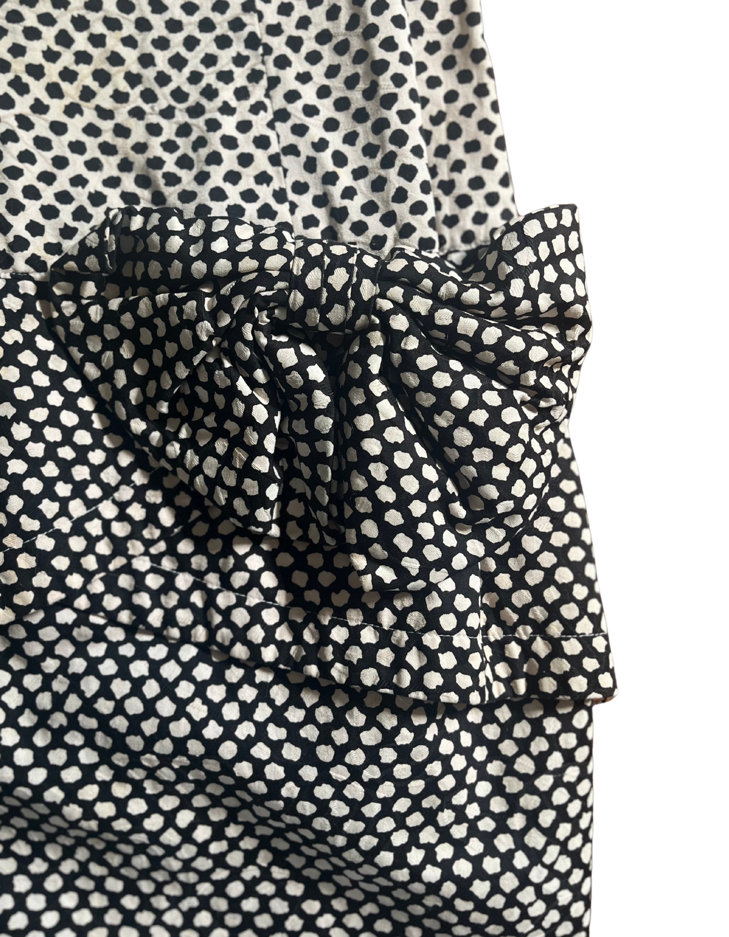 Bow image of black and white polka dop 1980s ruffle sleeve dress on light background.