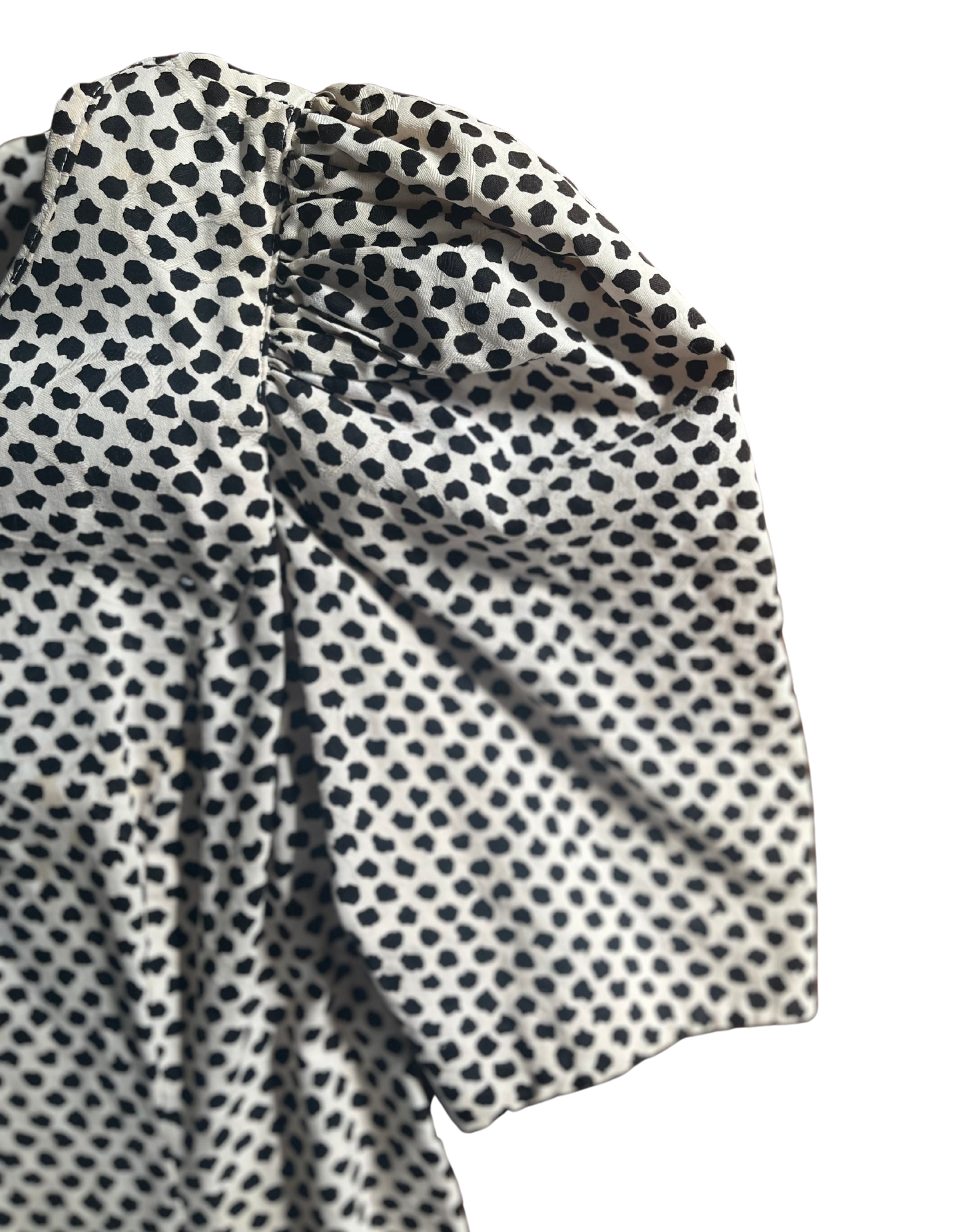 Sleeve image of black and white polka dop 1980s ruffle sleeve dress on light background.