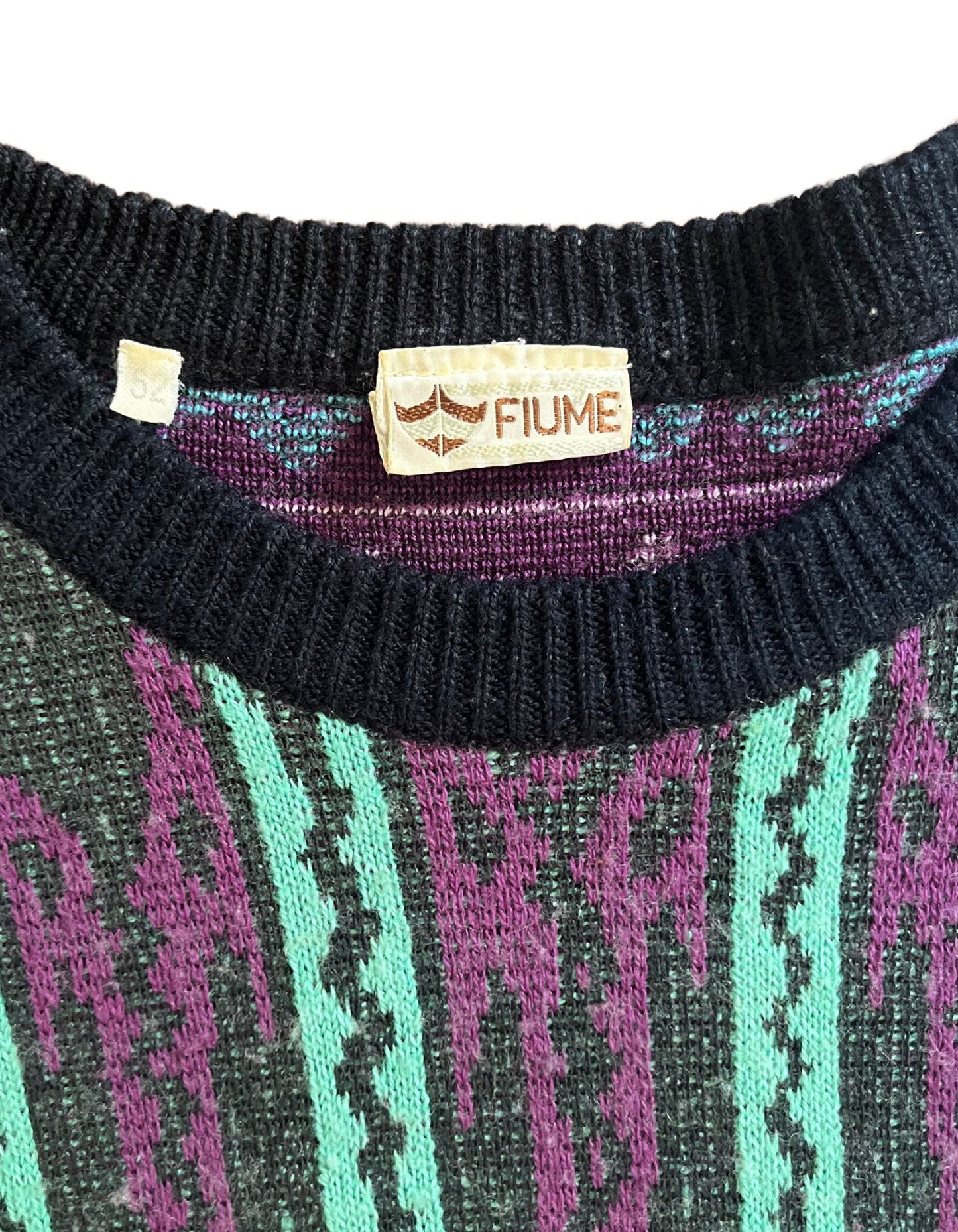 Tag image of vintage purple, teal and black cosby sweater on white background.