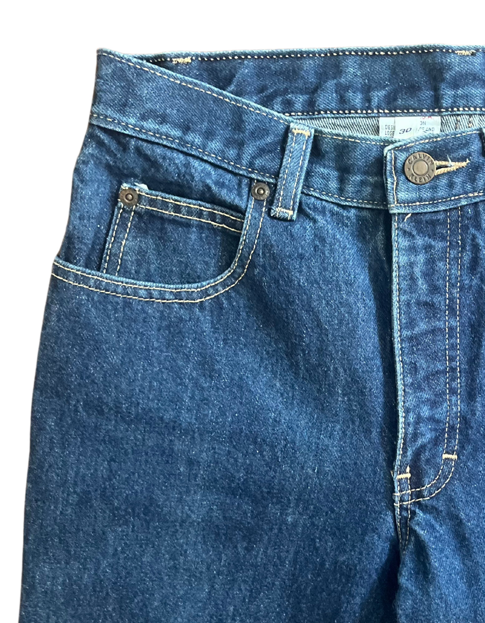 Front pocket image of dark vintage calvin klein jeans on white background.