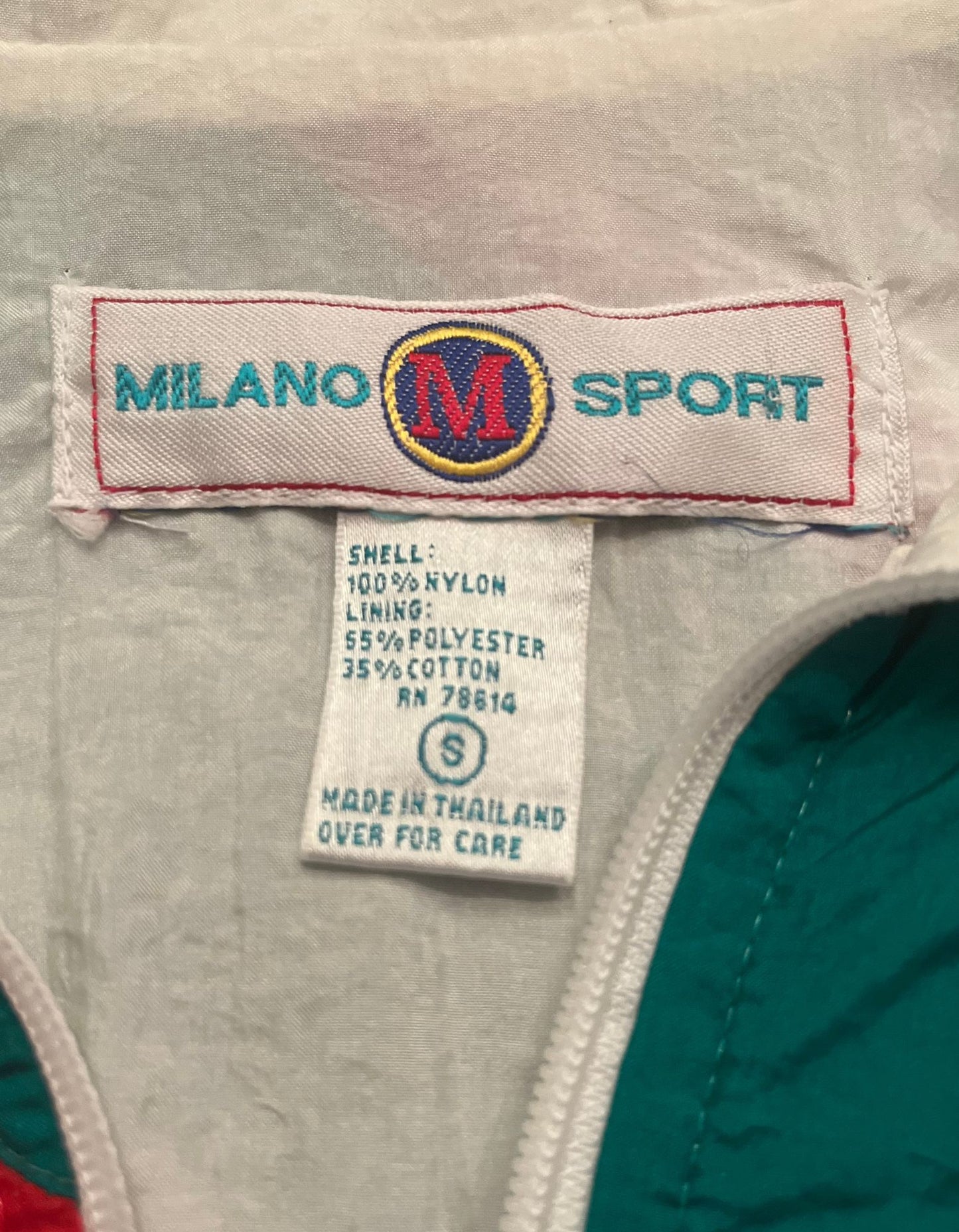 Close up image of tag on white colorblock windbreaker with embroidered trim.