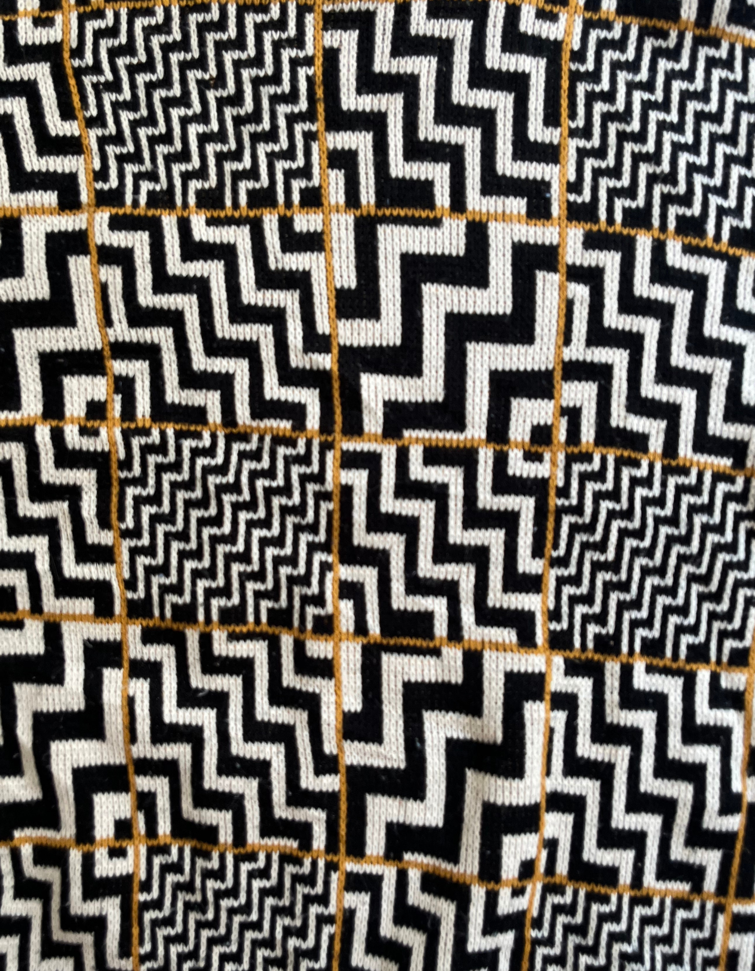 Front close up image of black and white zig zag sweater on white background.