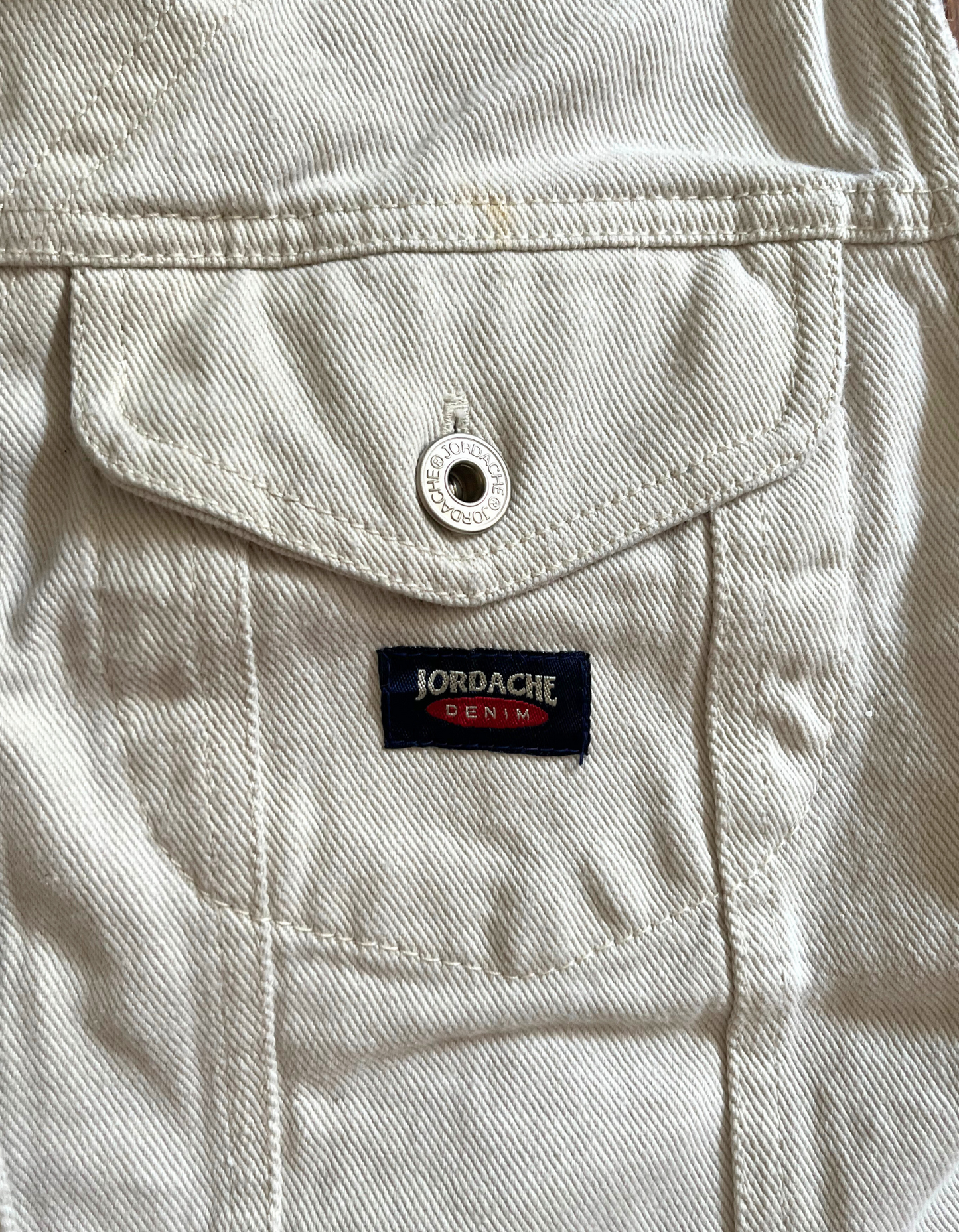 Close up front image of white Jordache denim vest on white background.