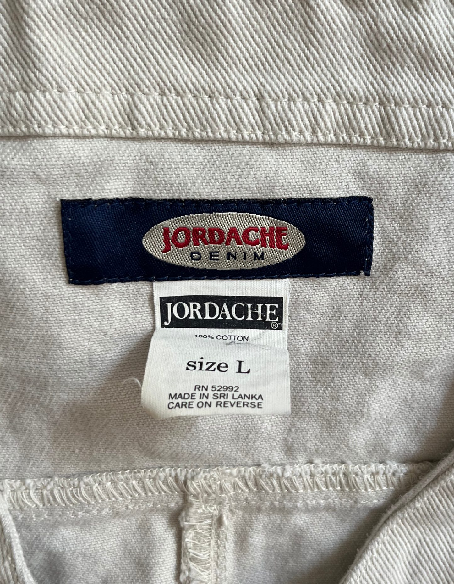 Tag image of white Jordache denim vest on white background.