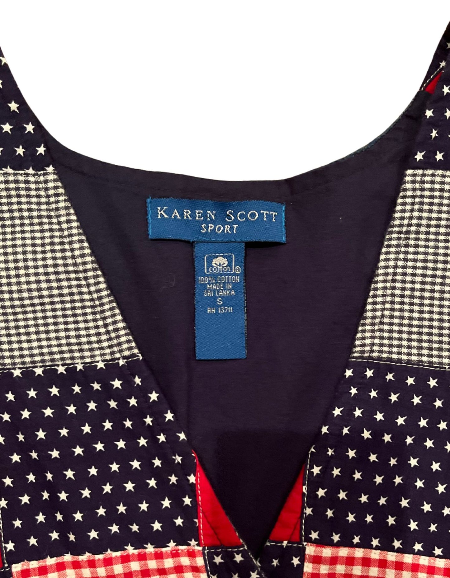 Close up image tag of vintage red, white and blue Karen Scott vest with silver buttons on white background.