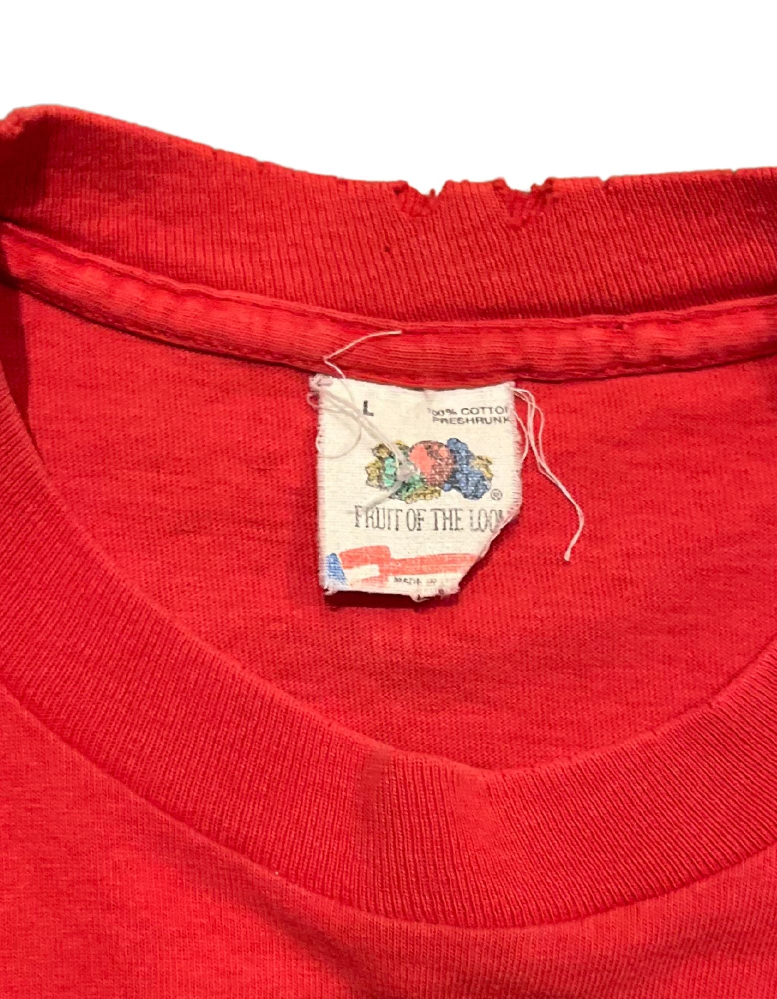 Front of red 1988 Dukacrat tshirt with white text on white background close up on tag.