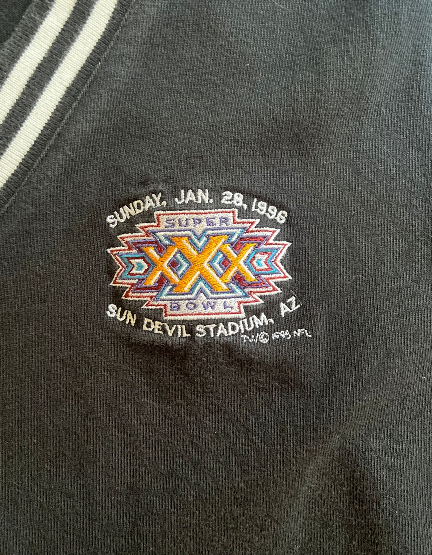 Close up image of 1996 super bowl black vest on white background.